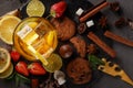 Ice tea in a glass on a black plate with biscuits, sweets and fruits on a black background Royalty Free Stock Photo