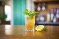 ice tea glass with lemon wedge and mint on a wooden table Royalty Free Stock Photo