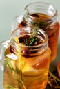 Ice Tea with Lemon Berry and Fresh Rosemary in Glass Jars Green Background Health Summer Drink Close Up