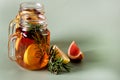 Ice Tea with Lemon Berry and Fresh Rosemary in Glass Jars Green Background Health Summer Drink Horizontal