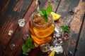 Ice tea with lemon slices and mint in glass jar, on rustic wooden background Royalty Free Stock Photo