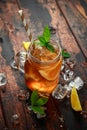 Ice tea with lemon slices and mint in glass jar, on rustic wooden background Royalty Free Stock Photo