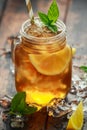 Ice tea with lemon slices and mint in glass jar, on rustic wooden background Royalty Free Stock Photo