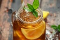 Ice tea with lemon slices and mint in glass jar, on rustic wooden background Royalty Free Stock Photo
