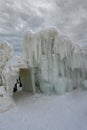 An ice wall created from water and icicles next to a small tunnel made of ice and snow at the Ice Castle show