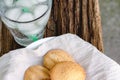 Ice and water in glass and ancient egg cakes in plate on wood stump