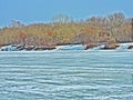 Ice waves of frozen river, coast with trees in march Royalty Free Stock Photo