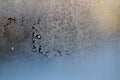 Ice on a window glass in winter. Blue snowdrifts peek through the frost. Drops of melted hoar and yellow winter sun. Weather Royalty Free Stock Photo