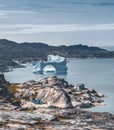 Iceberg with an arch in Antarctic Greenland waters against the backdrop of the mountains of the Arctic Peninsula. Small Royalty Free Stock Photo