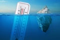 Iceberg in clear blue water and hidden danger under water. Global Warming Concept. Floating ice and a thermometer with a high Royalty Free Stock Photo