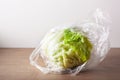 Iceberg lettuce salad vegetable in plastic bag. single use plastic packaging issue Royalty Free Stock Photo