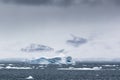 An iceberg and mountains in clouds