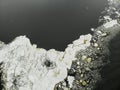 Iceberg pieces of ice lake sea gulf black water. Aerial drone view. Flying over