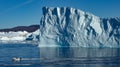 Iceberg of triangular shape with abrupt sides on a calm sea with a boat Royalty Free Stock Photo