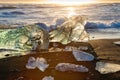 Icebergs on the cost of the black sand beach in the rays of the rising sun, Jokulsarlon, southeast Iceland