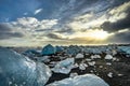 Icebergs floating in Jokulsarlon at sunset golden hour with glac