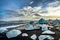 Icebergs floating in Jokulsarlon at sunset golden hour with glac