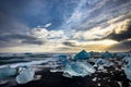 Icebergs floating in Jokulsarlon at sunset golden hour with glac