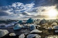 Icebergs floating in Jokulsarlon at sunset golden hour with glac