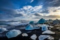 Icebergs floating in Jokulsarlon at sunset golden hour with glac