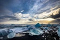 Icebergs floating in Jokulsarlon at sunset golden hour with glac