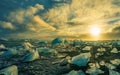 Icebergs floating in Jokulsarlon at sunset golden hour with glac