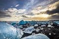 Icebergs floating in Jokulsarlon at sunset golden hour with glac