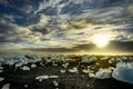 Icebergs floating in Jokulsarlon at sunset golden hour with glac
