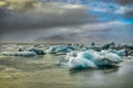 Icebergs floating in Jokulsarlon at sunset golden hour with glac