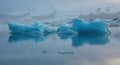Icebergs floating on water reflection blue tones dramatic lighting Royalty Free Stock Photo