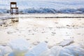 Icebound chair near ice hole in frozen lake
