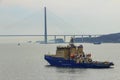 Icebreaker `Novorossiysk` on the inner roadstead of the port of Vladivostok on the background of the Russian bridge