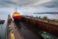 Icebreaker ship enters floating dock for repairs, maritime industry maintenance in dockyard. Marine transportation Royalty Free Stock Photo