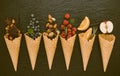 Icecreams with fruit and nut ingredients - ice cream cones on a black background