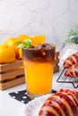 Iced americano black coffee with layer of fresh orange juice and decorated with croissant and orange, ready to serve for Royalty Free Stock Photo