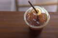 Iced Americano coffee in take away cup plastic glass on the wo Royalty Free Stock Photo