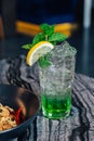 Iced Apple Soda with sliced lemon and mint leaves in drinking glass on marble top table Royalty Free Stock Photo