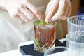 Iced black coffee mojito - A glass of Cold brew coffee mixed with brown sugar, tropical fruit and mint on blurred background,