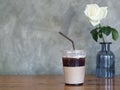 Iced Black Coffee in plastic cup on wooden table, White rose background. Royalty Free Stock Photo