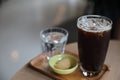 Iced black coffee on wooden tray in coffee shop