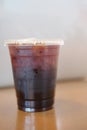 Iced black coffee on wooden table