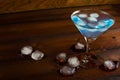 Iced blue cosmopolitan cocktail on wooden background