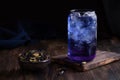 Iced butterfly pea flower with dry petals, glass with blue anchan tea