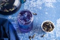 Iced butterfly pea flower tea, glass of blue anchan and dry clitoria ternatea