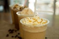 Iced caramel coffee frappe with whipped cream in plastic glass