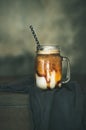 Iced caramel macciato coffee with milk in jar, copy space