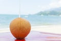 Iced coconut on a beach kiosk table..Brazilian tropical beach in hot summer on Ilhabela.