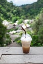 Iced coffee on balcony with Mae Kampong village background