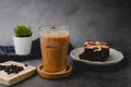 Iced coffee with coffee, bean, and brownie on black stone background. Drink and refreshing concept for summer. horizontal