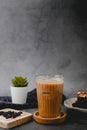 Iced coffee with a coffee, bean and brownie or a chocolate cake with copy space I\'m black background. vertical